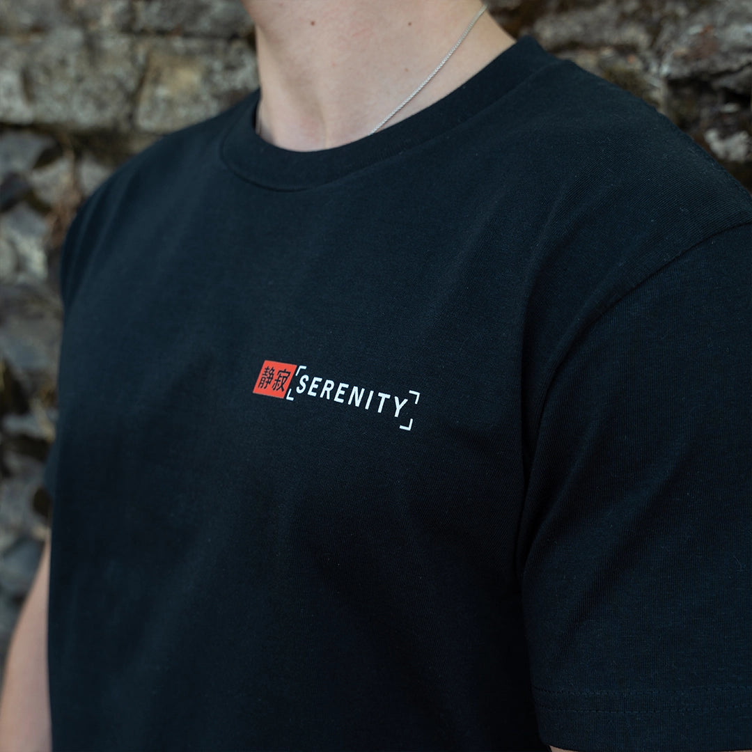 ArcaLoot Serenity black T-shirt with Japanese and English front logo, worn by a model.