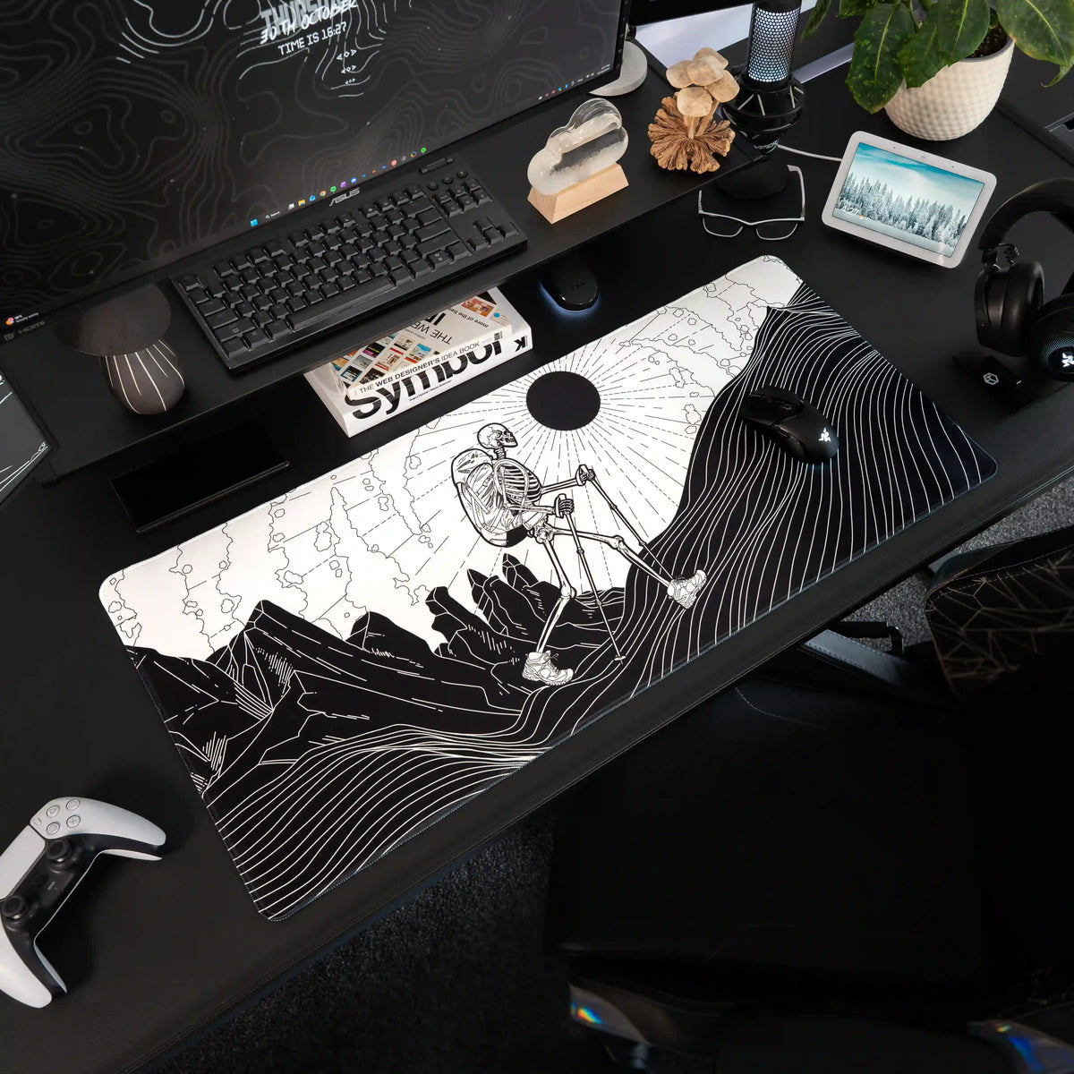 Large ArcaLoot gaming mousepad with a Skeleton figure hiking against a mountain landscape on a black gaming setup. Bare Boned Expedition.