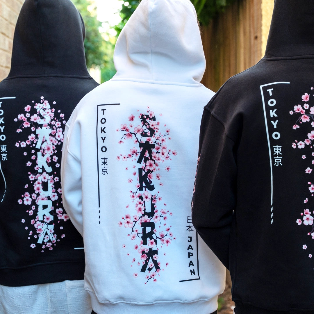 ArcaLoot Sakura Hoodie collection. Black and white hoodies worn by three models featuring cherry blossom Sakura designs.