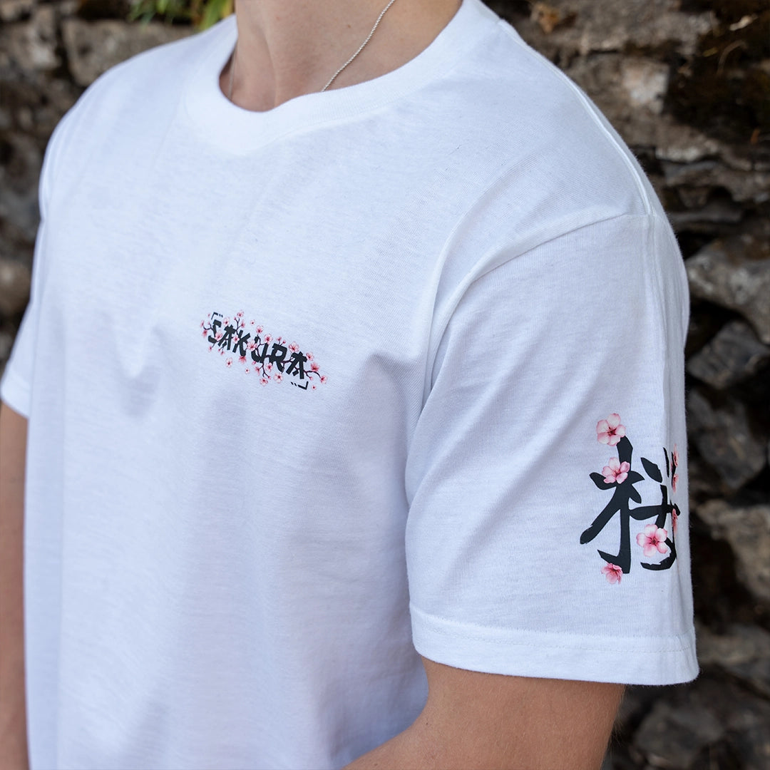 ArcaLoot Sakura white T-shirt with Japanese cherry blossom and Sakura text front logo. Cherry blossom arm sleeve design visible.