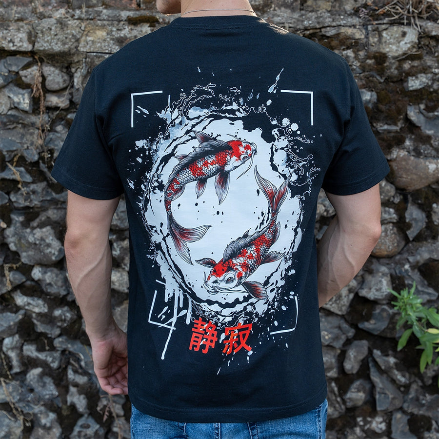 ArcaLoot Serenity black T-shirt with Japanese koi fish back design, worn against a cobblestone wall.