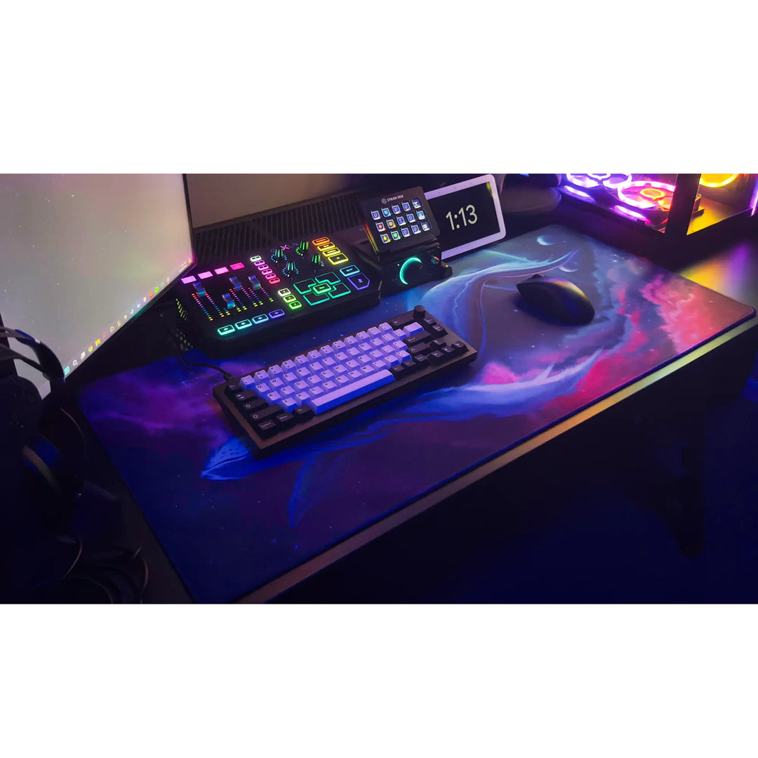 Large ArcaLoot gaming mousepad with a blue whale design against a colorful cosmic background on a black gaming desk. Cosmic Cetacean.