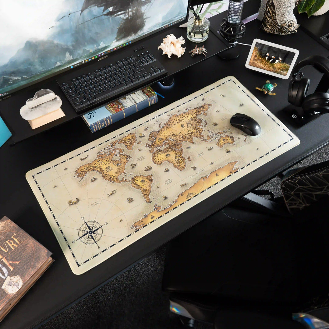Decorative desk setup with a Large Arcaloot gaming mousepad featuring a world map design. Unchartered Earth. Fantasy Map.