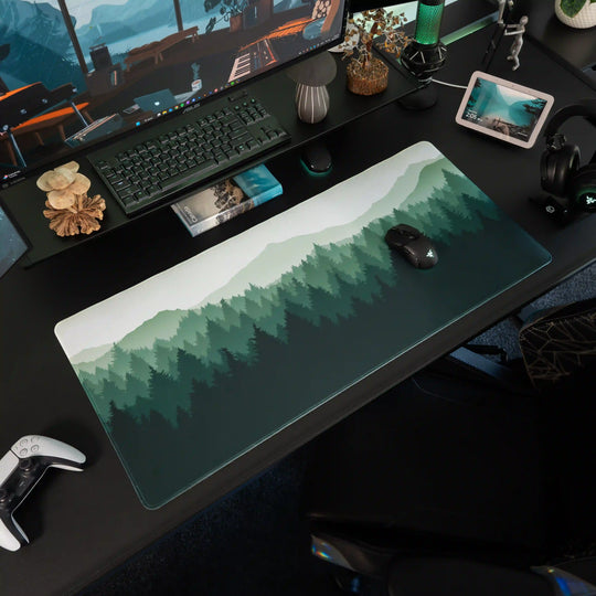 Large ArcaLoot gaming mousepad with green forest and mountains design on a black gaming desk. Wild Emerald. 