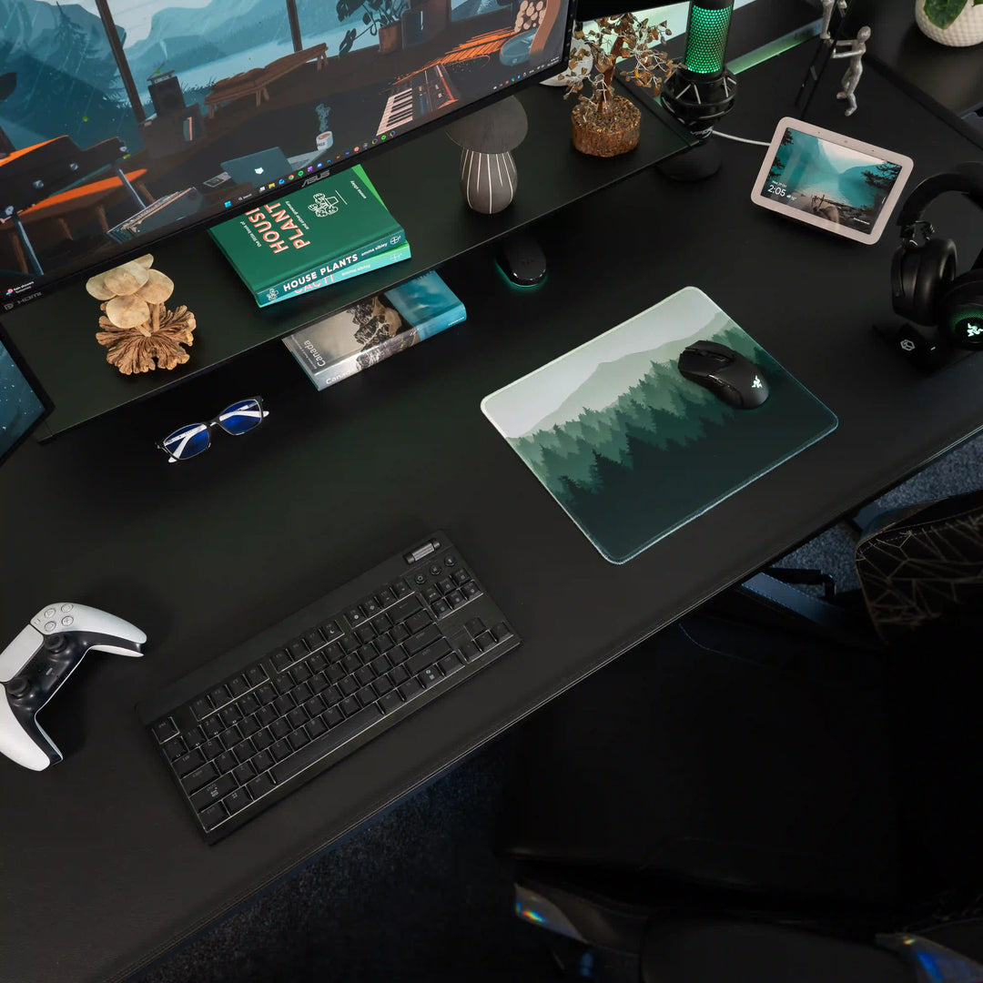 Small ArcaLoot gaming mousepad with green forest and mountains design on a black gaming desk. Wild Emerald. 