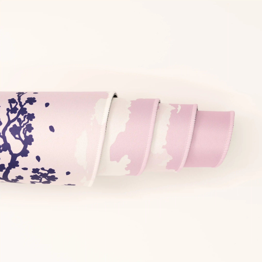 ArcaLoot Gaming Mousepad curled to show premium stitched edges - Sakura Cityscape