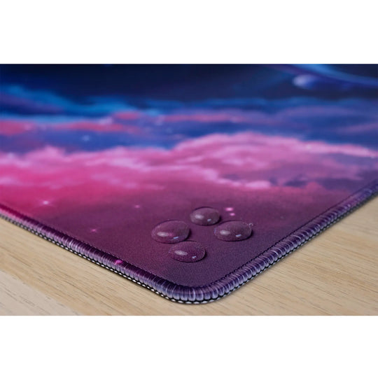 Clear water droplets on an ArcaLoot gaming mousepad featuring stitched edges. Cosmic Cetacean.