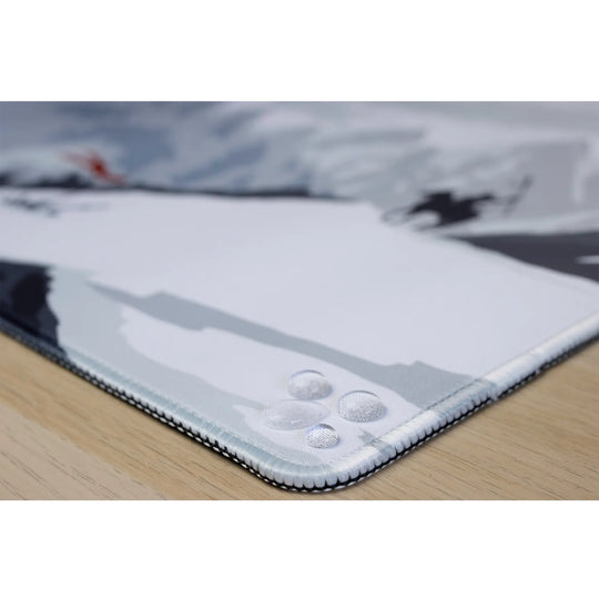 Clear water droplets on an ArcaLoot gaming mousepad featuring the stitched edges. Blade and Flame.